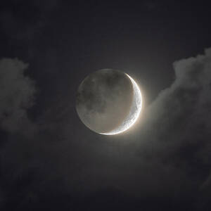 Shimmering Crescent Among Clouds by Brandon Wichmann